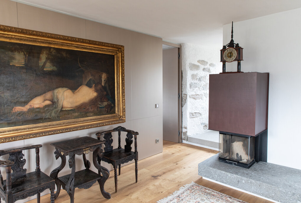 Fireplace next to an artistic painting and a seating area